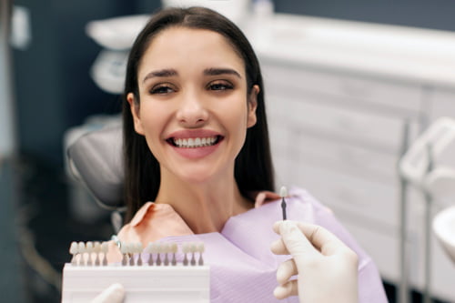 Patient undergoing a dental examination to assess the condition and longevity of porcelain veneers.